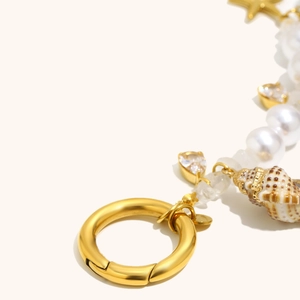 Detailed close-up of 18K gold-plated shell, starfish, and pearl charms for jewelry making