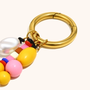 Macro d'un anneau doré 18K et de perles multicolores sur un porte-clés élégant