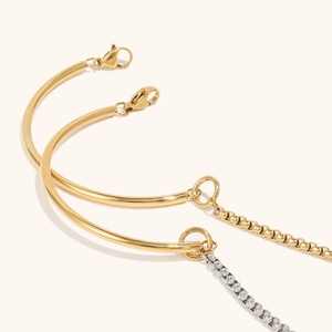 Detail of 18K gold plated stainless steel bangles with round pipe and box chain design