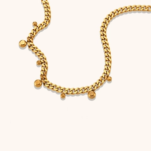 Detail of 18K gold plated Cuban chain necklace featuring round bead charms and links