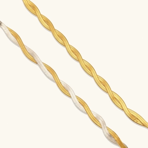 Macro detail of twisted flat snake chain necklaces in gold and bicolor steel finish