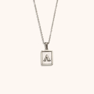 Détail du collier pendentif carré argenté avec lettre A sur incrustation nacre blanche