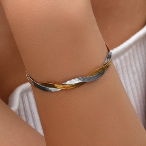 Detail of two-tone gold and silver twisted herringbone snake chain bracelet on wrist