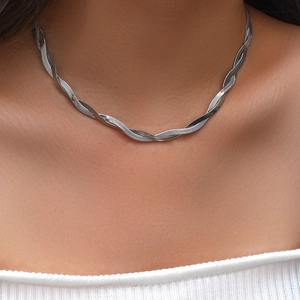Detailed close-up of triple-strand twisted herringbone snake chain necklace in silver