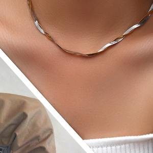 Close-up of twisted two-tone flat snake chain necklace in gold and silver finish