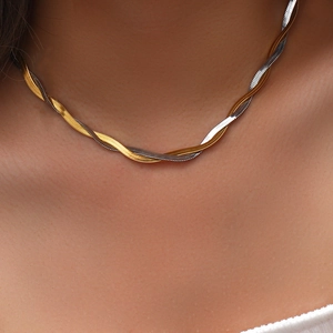 Close-up of a two-tone intertwined gold and silver flat snake chain necklace on a model