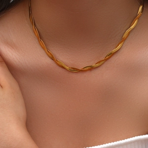 Macro shot of gold twisted herringbone necklace with flat snake chain texture