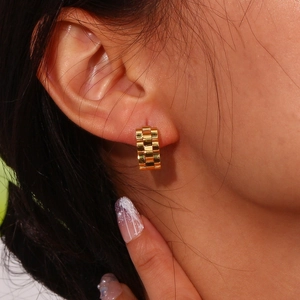 Close-up of gold watchband link earrings in polished 18K stainless steel worn by model