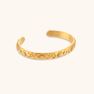 Macro shot of 18K gold plated stainless steel cuff with celestial sun and moon engraving