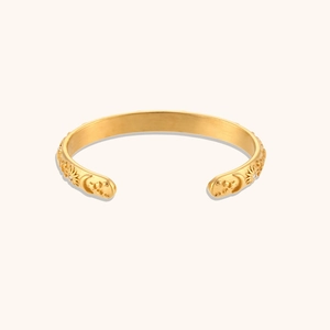 Detail of 18K gold-plated celestial bangle with sun, moon, and star relief carvings