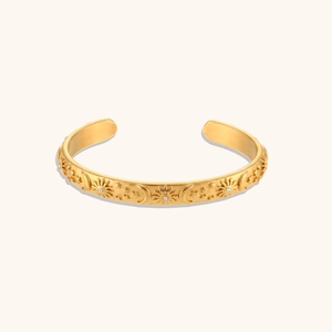 Detail of vintage 18K gold plated bangle featuring embossed sun, moon and star patterns
