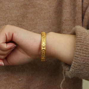 Detail of 18K gold plated celestial bracelet with sun and moon engravings and zircon