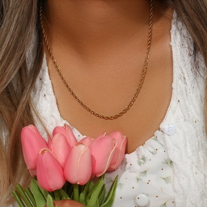 Détail d'un collier chaîne torsadée en acier plaqué or 18K sur un mannequin femme