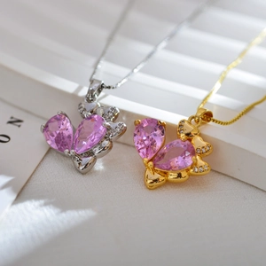 Detalle de colgantes de mariposa rosa con micro-pavé de cristales en oro y plata