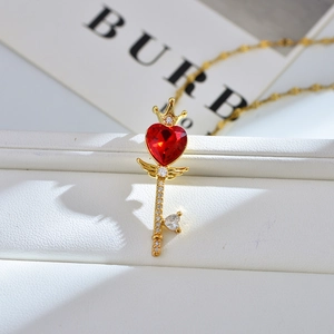 Detailopname van een luxe sleutelketting met rode hart-zirkonia en kroonvleugels