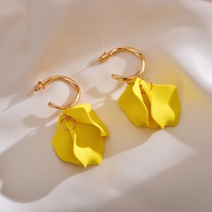Elegant bright yellow acrylic rose petal drop earrings with gold C-shaped rings on fabric