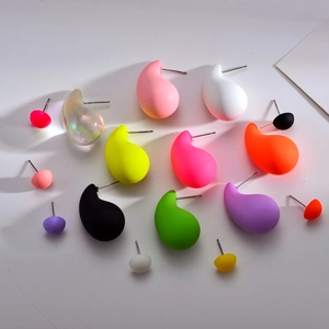 Gros plan de boucles d'oreilles gouttes en résine mates et brillantes de tailles variées