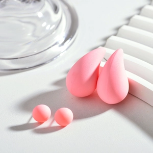 Vue macro de boucles d'oreilles goutte rose pastel et clous ronds en résine