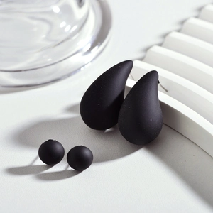 Détails de boucles d'oreilles en acrylique noir mat en forme de goutte et bouton chic