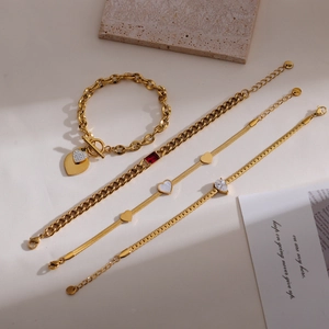 Detail view of gold-plated heart pendant bracelet set with ruby and zircon inlays