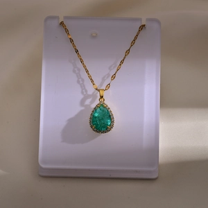 Elegante gouden halsketting met smaragdgroene druppel hanger en glanzende zirkonia's