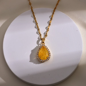 Elegante gouden druppelketting met geel kristal en witte zirkonia omlijsting