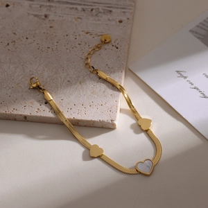 Gold snake chain necklace with three heart pendants featuring white mother of pearl inlay