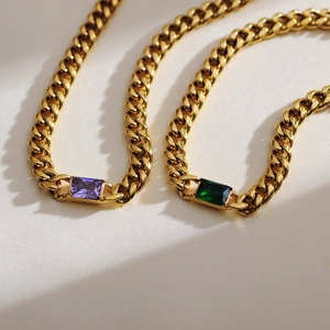 Detail von goldenen Zirkonia-Halsketten mit violetten und smaragdgrünen quadratischen Anhängern
