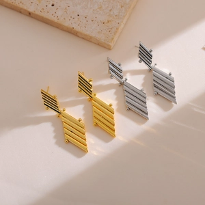 Orecchini geometrici metallici color oro e argento con texture a righe diagonali