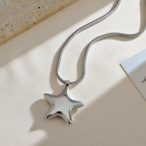 Detailweergave van een 3D-sterrenhanger met gepolijste afwerking aan een slangenketting