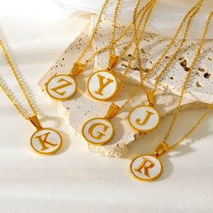 Gouden titanium stalen ketting met witte schelphanger en ronde hoofdletterletters
