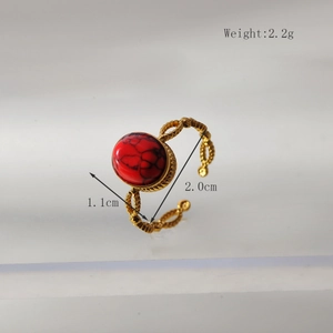 Detailweergave van gouden open ring met rode ovale steen en geweven textuur