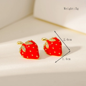 Macro view of mini red strawberry stud earrings with gold plating and zircon details
