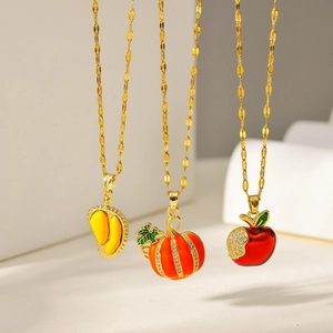 Detailed view of gold fruit pendants including durian, pumpkin and red apple on fine chains