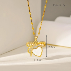 Detail van een 3g hartvormige hanger met strik en parels aan een gouden ketting