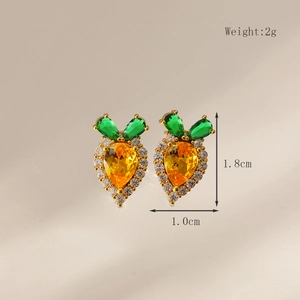 Macro shot of carrot earrings with orange and green stones and white crystal halo