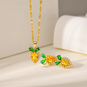 Detail view of carrot-shaped gold necklace and earrings set with yellow zircons