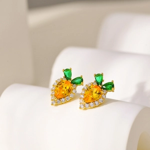Macro detail of carrot stud earrings with orange and green teardrop cubic zirconia