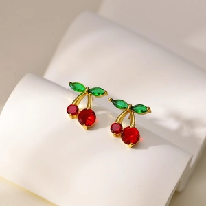 18K gold plated cherry earrings with red stones and green marquise gems on white stand