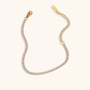 Detail of 18K gold plated tennis bracelet featuring claw-set cubic zirconia and lobster clasp