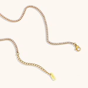 Macro detail of 18K gold plated 2mm zircon chain necklace with lobster clasp and tag