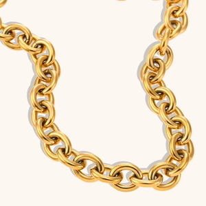 Dettaglio della collana a catena dorata spessa con maglie tonde lucide e riflessi metallici