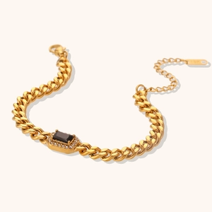Close-up of 18K gold Cuban chain bracelet with black stone and zircon border detail