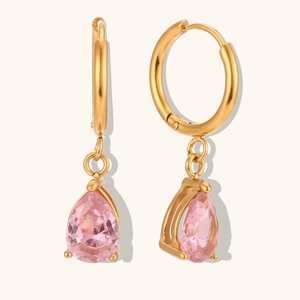 Détail des boucles d'oreilles créoles dorées avec pendentifs en zircon rose poire