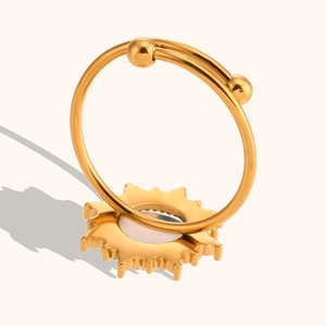 Detalle de anillo de sol dorado con incrustación de ópalo y banda ajustable pulida