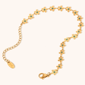 Close-up of gold-plated flower bracelet with blue enamel petals and K18 hallmark tag