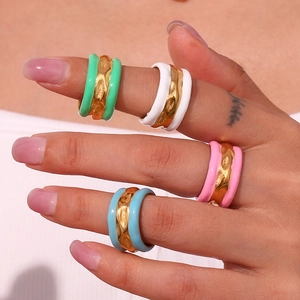 Nahaufnahme von vier bunten Wellenringen aus Emaille in Mint, Rosa, Weiß und Blau