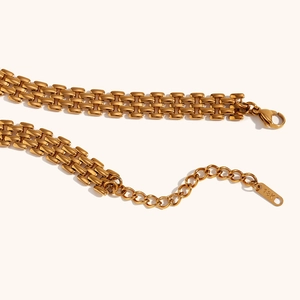 Vista macro della collana a cinturino d'orologio in acciaio placcato oro 18K con moschettone