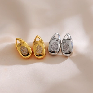 Détail macro de boucles d'oreilles goutte avec cristaux sur tissu en satin
