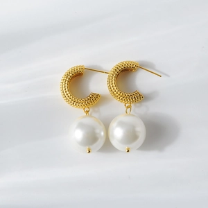 Dettaglio macro di orecchini a C placcati oro 18K con trama intrecciata e perle bianche